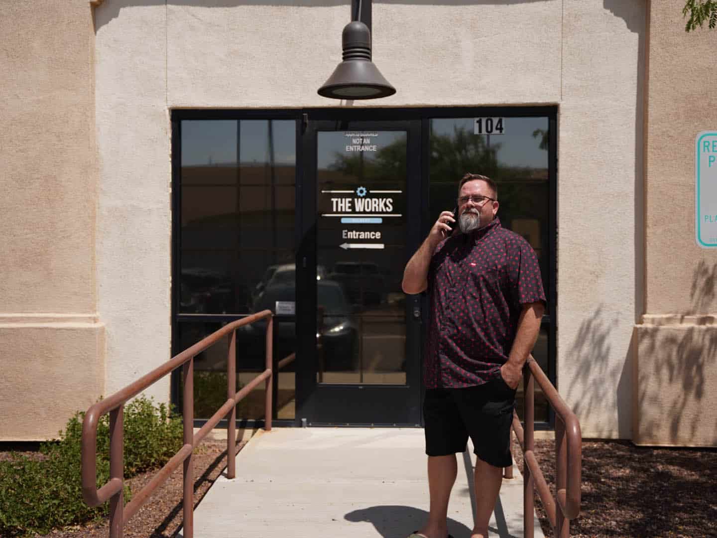 Mike Rux, a seasoned digital marketing strategist at Ciphers Digital Marketing in Gilbert, AZ, stands outside the modern office building, engaged in a dynamic phone conversation with a colleague.
